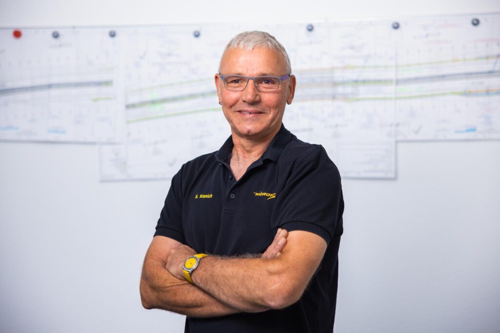 Bauleiter bei Morof vor Plänen im Hintergrund