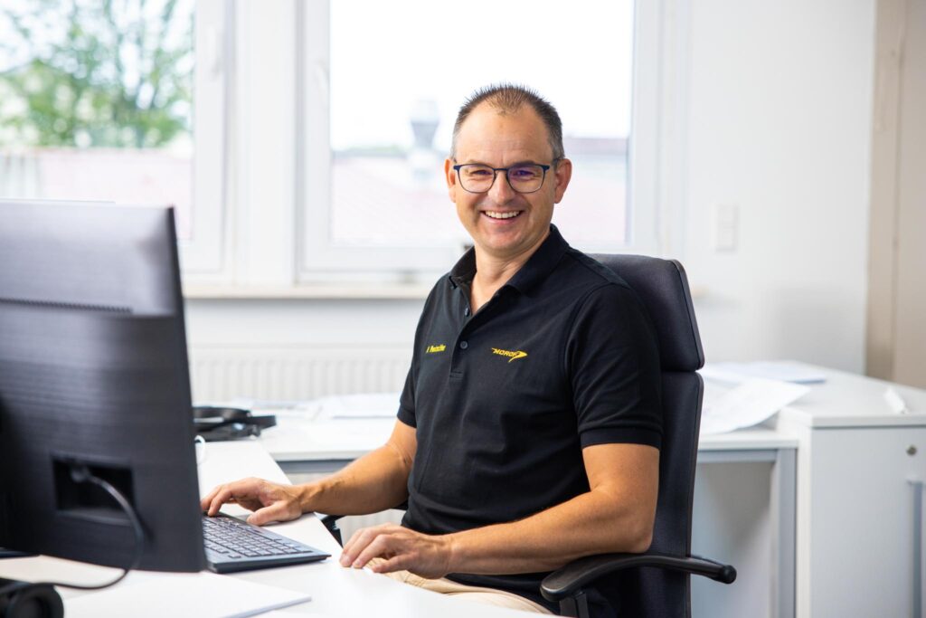 Morof Mitarbeiter der am Schreibtisch vor dem Computer sitzt.